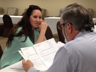 Gatlinburg wildfire survivor Melissa Starling  receives advice from pro bono attorney David Draper of Knoxville, at a legal clinic in Sevierville, Tenn. on April 1, 2017