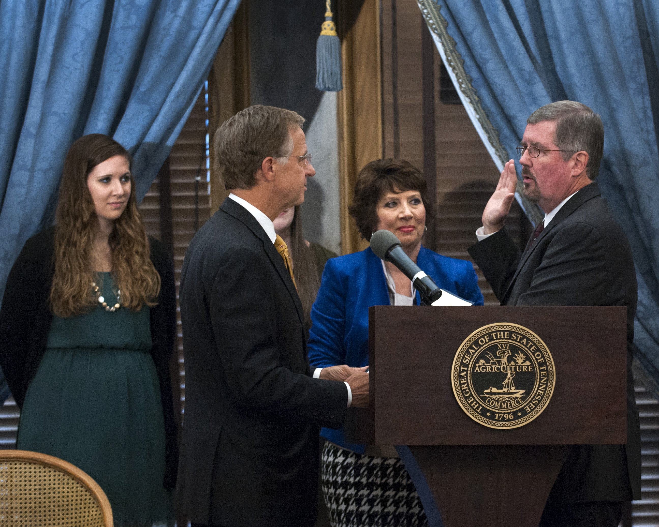 Gov. Bill Haslam administers the oath to Chief Justice Bivins as his family looks on.