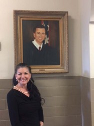 Danna Walker stands in front of the portrait she painted of her husband Judge Joe H. Walker III, which now hangs in the Lauderdale County Courthouse